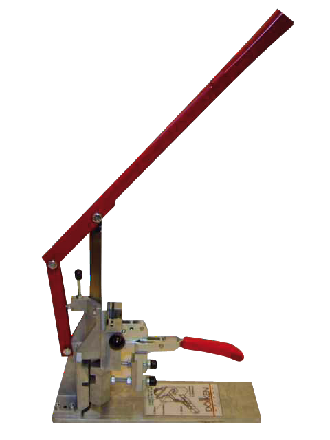 WOLFF_Dummy_15915_skirting board punching machine_2025-08 Een handmatige bankpers met een lange rode hendel en een klein rood handvat gemonteerd op een metalen basis, gebruikt voor het ponsen of persen van kleine onderdelen. De pers heeft een scharnierende arm, verstelbare onderdelen en een rechthoekige basisplaat met gedrukte instructies.